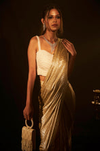Load image into Gallery viewer, Shop Designer Metallic Shimmer Slit Saree &amp; Embellished Pearl Blouse  for Women Online at Tasuvure. Buy Stylish Nude Saree &amp; attached Palla for Weddings &amp; Events Saia metallic slit saree with an embellished pearl blouse will definitely make you look sassy and elegant in an event. Tailored to perfection in a metallic fabric, the saree features a slit from the waist level and has an attached palla which creates a great fall. It comes with a pearl embellished blouse with dori attachments on the back.