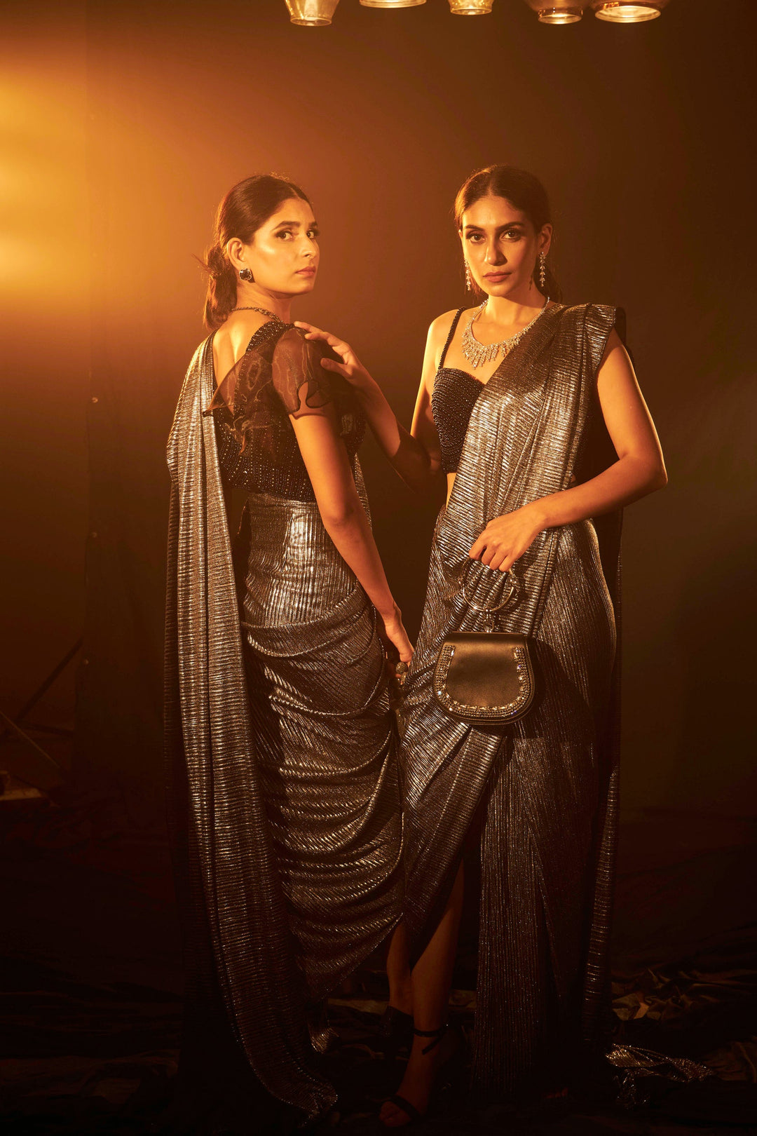 Saia metallic slit saree with an embellished pearl blouse will definitely make you look sassy and elegant in an event.  Tailored to perfection in a metallic fabric, the saree features a slit from the waist level and has an attached palla which creates a great fall.  It comes with a pearl embellished blouse with dori attachments on the back.